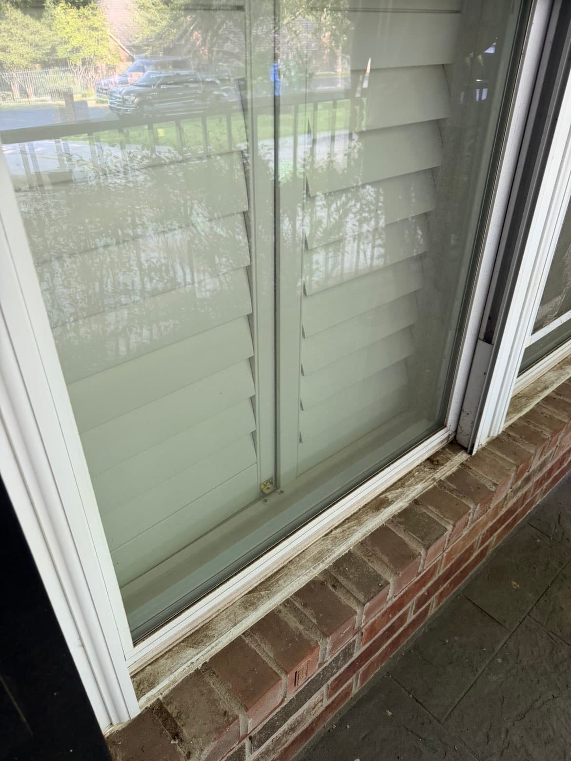 Sliding glass window before cleaning, viewed from outside through the pane
